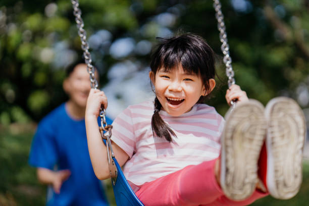 istock Happp Asian kid playing at playground with her father 1303959440