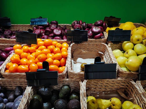 A vegetable store with empty black price tags. Fresh vegetables on the shelves at the supermarket, mockup price. Vegetable shop or market, copy space, background. Retail concept.