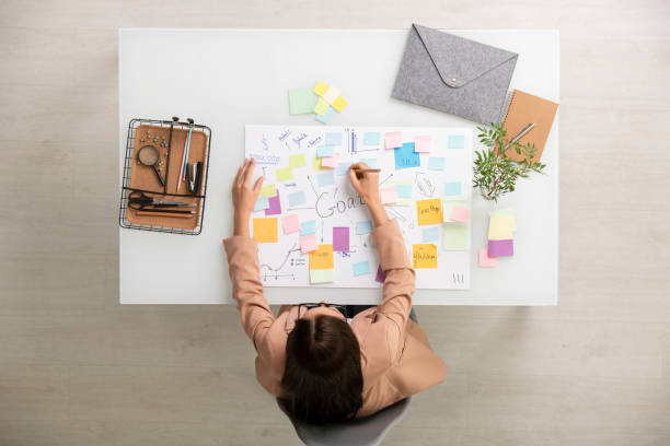 istock Overview of young elegant businesswoman making working notes on document 1303970004