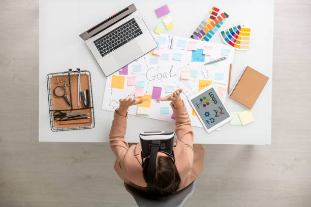 istock Top view of creative female with vr headset preparing presentation by workplace 1303970009
