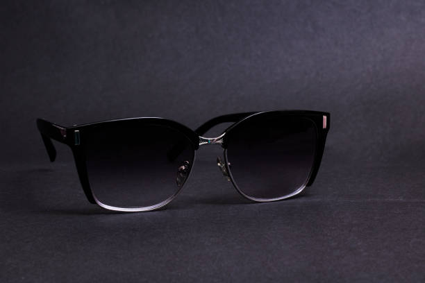 istock Black sunglasses on a black background closeup 1303974376