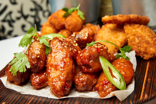 istock Sesame fried chicken wings with sauce and parsley. Close-up, selective focus. 1303976483