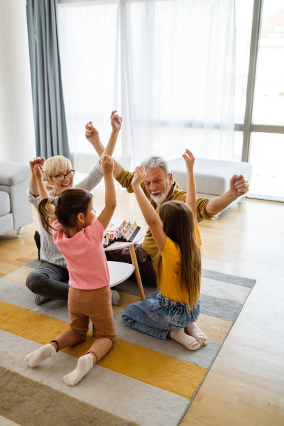 istock Grandchildren having fun at home while playing with their grandparents 1303977439