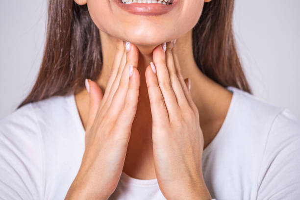 Close up of young woman rubbing her inflamed tonsils, tonsilitis problem, cropped. Woman with thyroid gland problem, touching her neck, girl has a sore throat Close up of young woman rubbing her inflamed tonsils, tonsilitis problem, cropped. Woman with thyroid gland problem, touching her neck, girl has a sore throat lymph node photos stock pictures, royalty-free photos & images