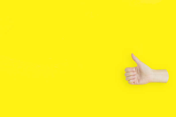 istock Hands Showing Thumb Up Sign on yellow background. 1303979036