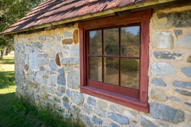 Stone Colonial building exterior and antique six-pane window at the Daniel Boone Homestead in Pennsylvania,