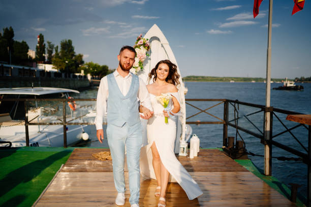 istock wedding ceremony by water on dock. bride and groom. 1303981679