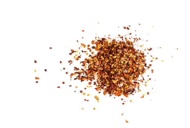 istock Red Chilli Pepper Flakes with Seeds Isolated 1303983353