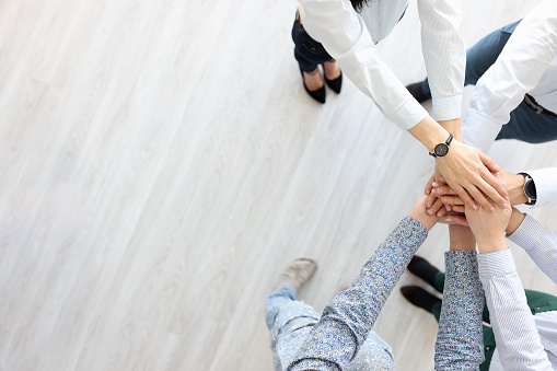 Partners stand and hold their hands in single gesture. Search for business partners concept