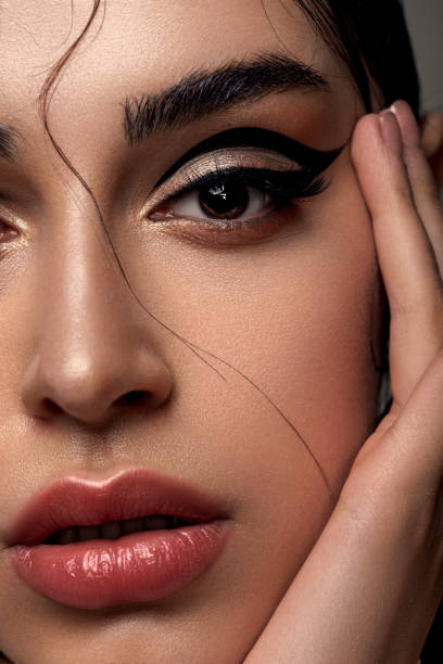 beautiful woman with evening glamorous make-up with a huge chain on her neck Young fashion woman with evening make-up in the form of graphic arrows on her eyes. Glossy healthy skin. stage make up stock pictures, royalty-free photos & images