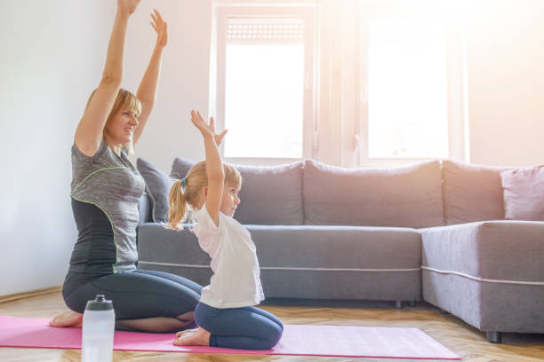 istock Mother and daughter stretching after exercising at home 1303986205