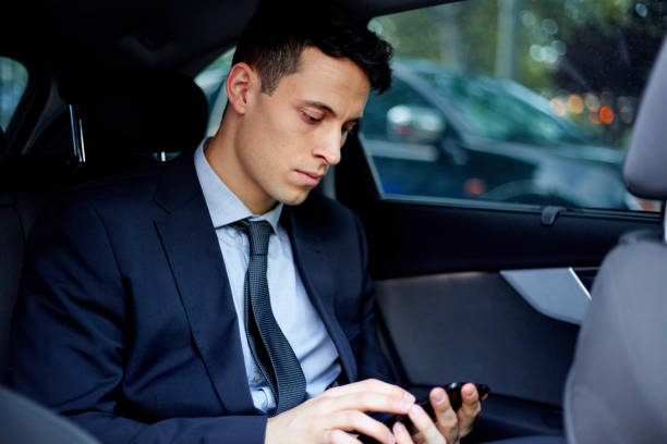 istock Business executive talking on mobile phone while traveling in car 1303987143