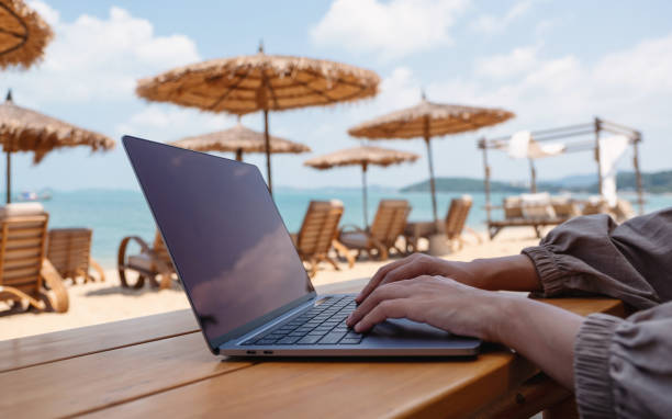 istock a woman working and typing on laptop computer on the beach 1303987240