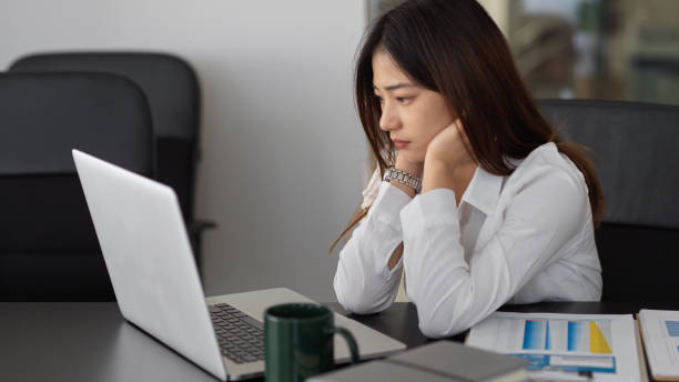 istock Female entrepreneur concentrating on her work with laptop and paperwork 1303987996