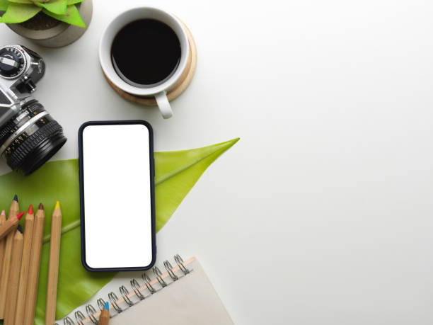 istock Creative workspace with smartphone, camera, coffee cup, stationery and copy space 1303988089