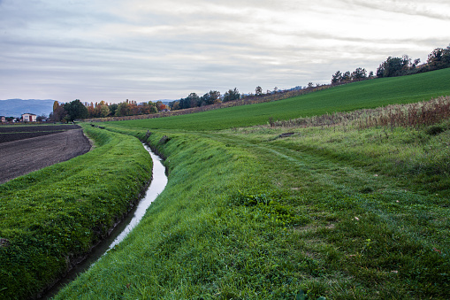 Scenic view of italian countryside field and water canal, Torrechiara, Parma, Italy