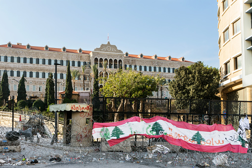 Beirut, Lebanon - December 22, 2019: Lebanese flag on barbed wires in front of the Lebanese government seat Grand Serail, Beirut, Lebanon