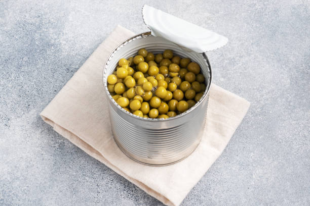 istock Tin open jar with canned peas on a gray concrete background. copy space. 1303990430