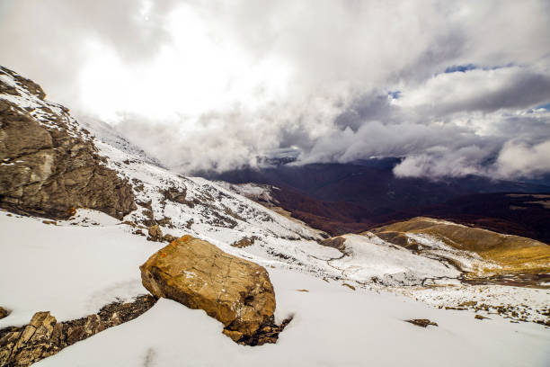 Panoramic view of italian snow capped mountain against rock and cloudy sky during hiking in autumn, Monte Cusna, Reggio Emilia, Italy