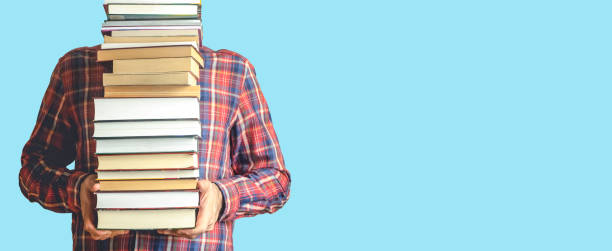 istock Student with books on a blank colored banner background. Education, reading and study background concept. 1303992879