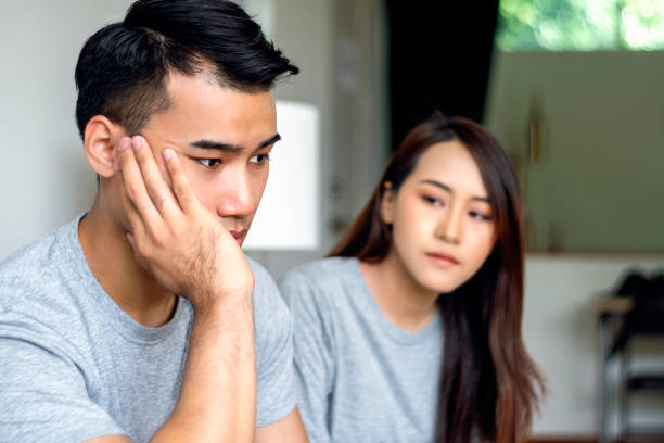 istock Trouble relationship couple married concept. Unhappy husband worried problem crisis something while after quarrel his wife sitting together on sofa at home. 1303992932
