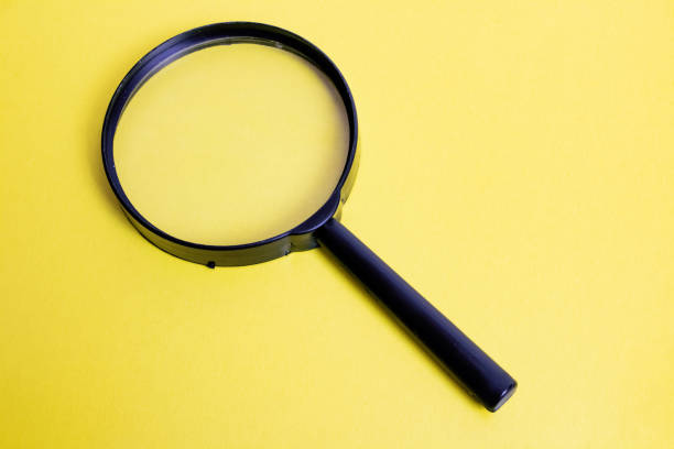 istock Big magnifier on a yellow background closeup 1303994421