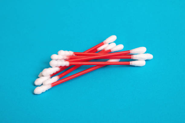 istock Pile of red cotton buds on blue background 1303994472