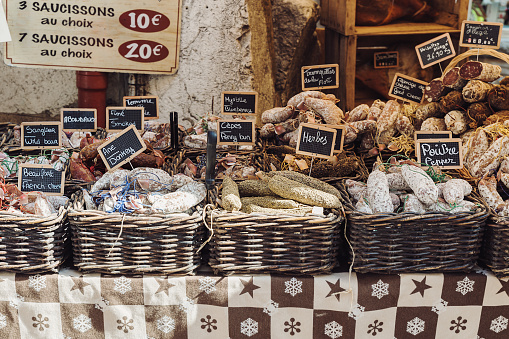 French open air market stand selling different kinds of salami - Annecy, Haute-Savoie