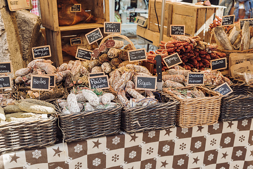 Open air market stand selling different kinds of salami - Annecy, France