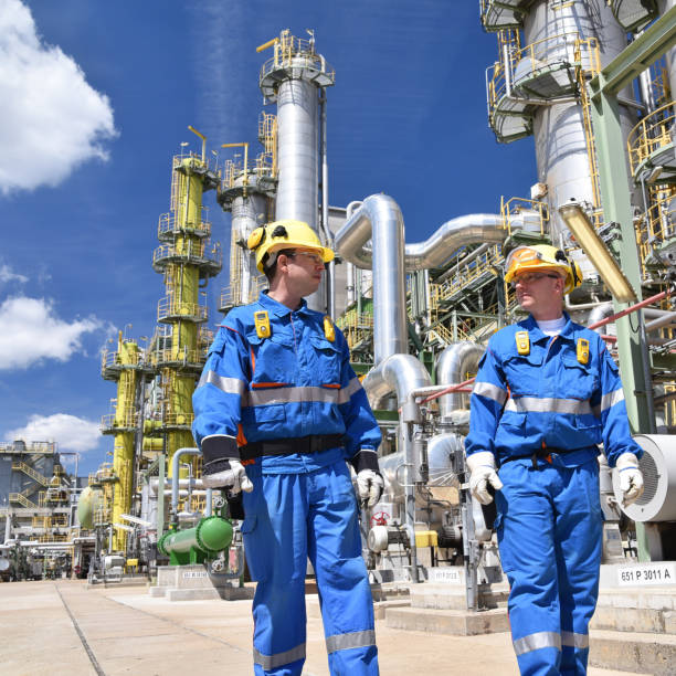 istock group of industrial workers in a refinery - oil processing equipment and machinery 1303997155