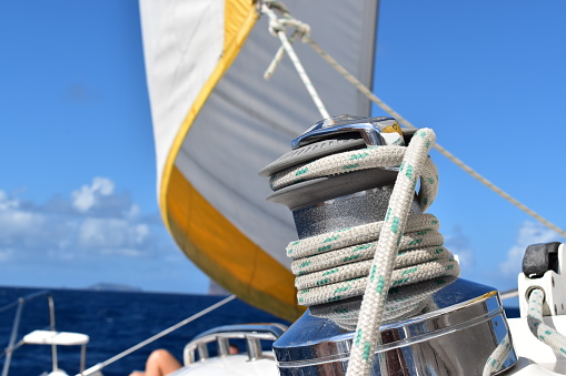 Boat equipment, shiny winch to tight ropes on a sailing boat. Adventure background