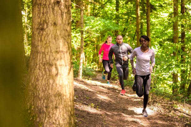 istock Women and man running on forest path 1303998064