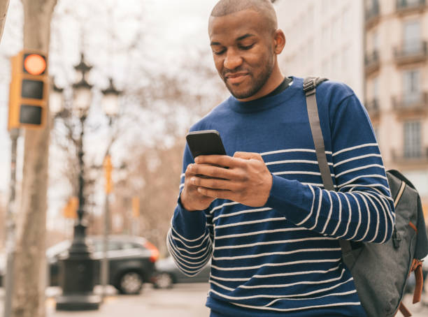 istock Young man using phone for video chat while walking in the street. 1303998072
