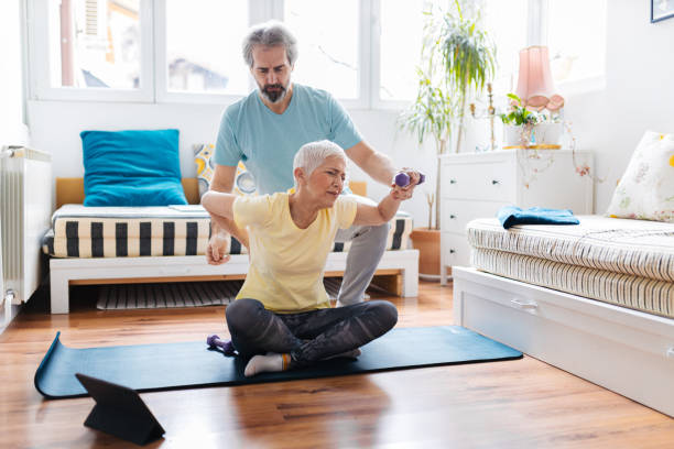 istock Senior couple doing exercises at home 1303998106
