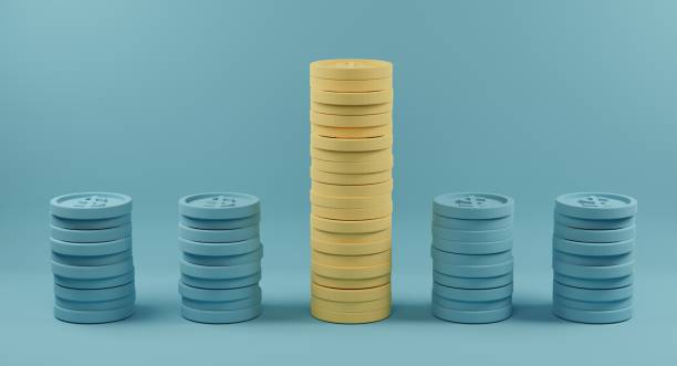 istock Yellow coin stacks standing out from crowd of identical blue fellows on light blue background 1303998441