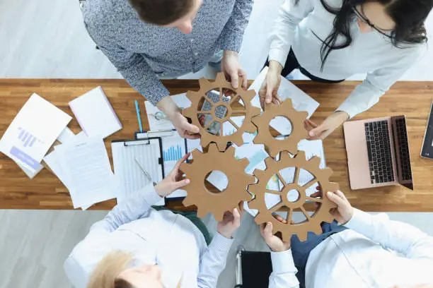 Photo of Employees in office connect gears in place