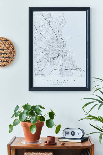 istock Stylish scandinavian living room interior with retro commode, black mock up poster frame, clock, plan, decoration, book and personal accessoreis in home decor. Template. 1303999897