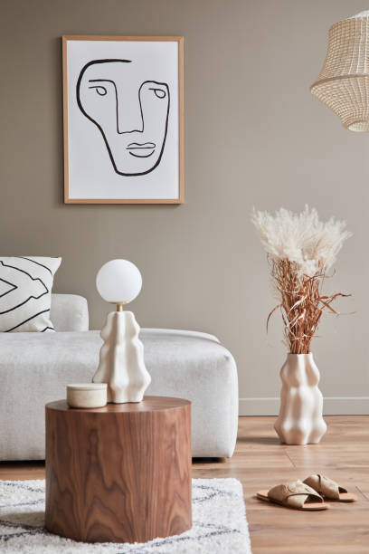 istock Stylish interior with design neutral modular sofa, mock up poster frames, coffee tables, table lamp, ceramic vessel, decoration, slippers and elegant personal accessories in modern home decor. 1304000228