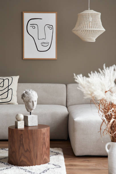 istock Stylish interior with design neutral modular sofa, mock up poster frames, coffee tables, dried flowers, decoration, pendant lamp and elegant personal accessories in modern home decor. Template. 1304000272
