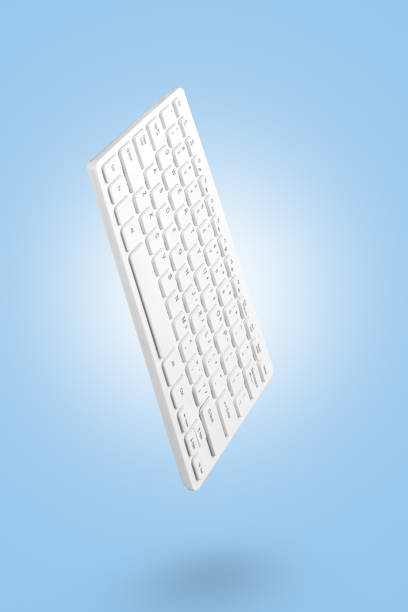 The white keyboard levitates against a blue background, the shadow is clearly visible. Studio photography. Concept for online work, training, commerce, web design. Empty space for text.