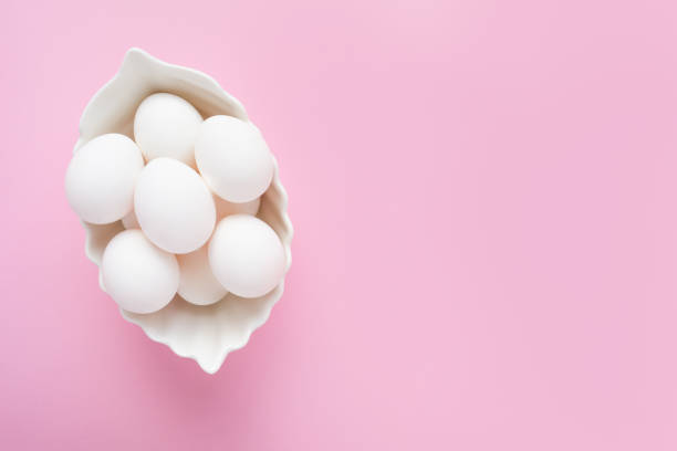 istock Many white eggs in a white dish on a pink background. Easter. Top view, copy space 1304003756
