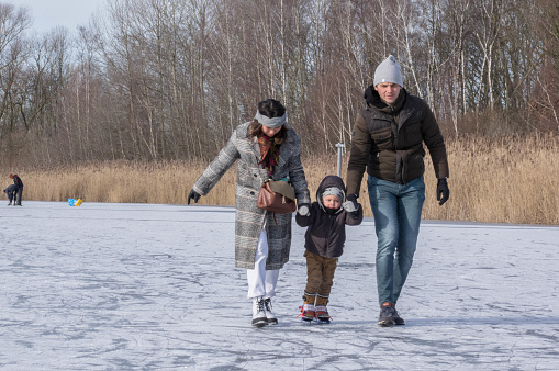 Family having iceskate fun on a cold winter sunny day