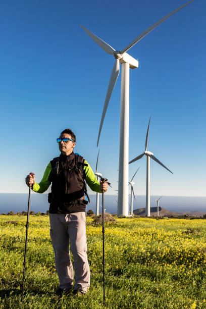 istock Hiker standing in blooming filed with windmills 1304009401