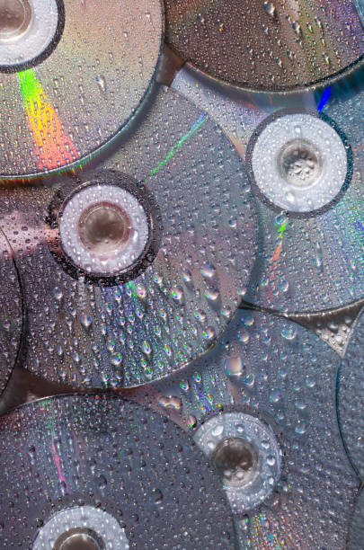 istock Vertical image of shiny and wet CD discs as a background 1304009553