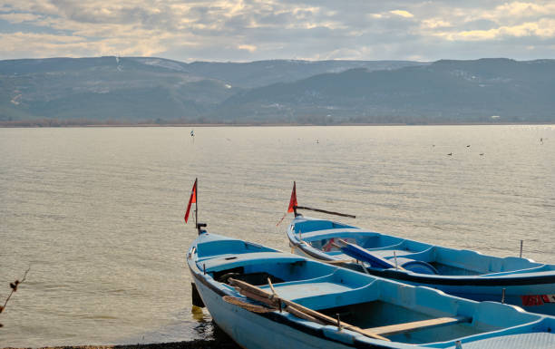 pequeños y azules barcos cerca de la costa del lago de uluabat en turquía. - turkish culture turkey fishing boat fishing fotografías e imágenes de stock