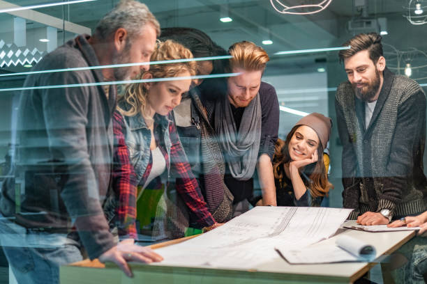 istock Group of building contractors examining blueprints in the office. 1304012252