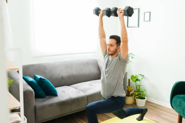 istock Hispanic man working out with weights at home 1304012504