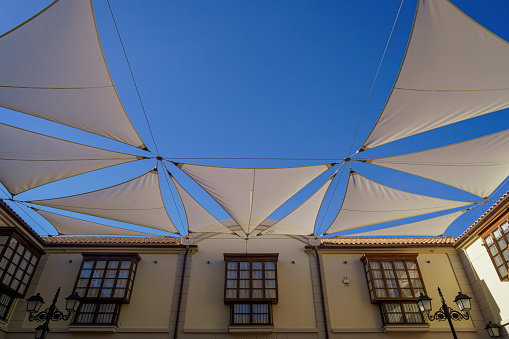 Malaga,Spain - February 02, 2021: White awning under the clear blue Sky in Big Commercial Center