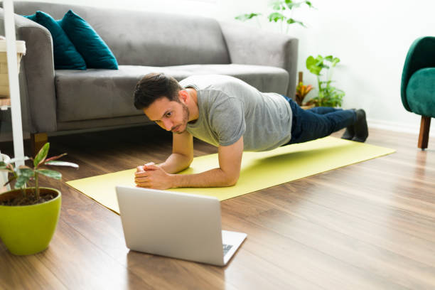 istock Latin man working out with a video tutorial in his living room 1304012719