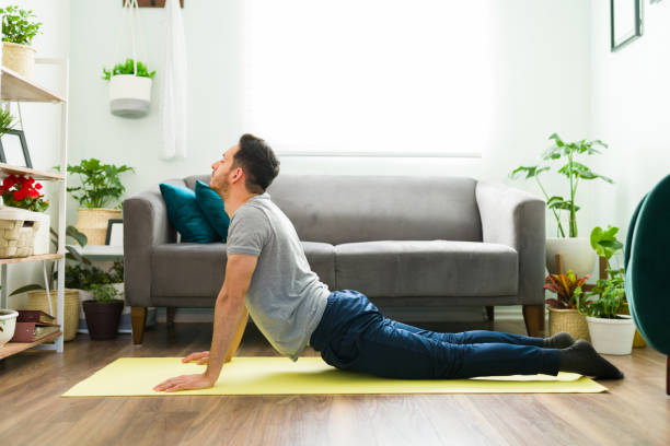 istock Hispanic man stretching his body with a yoga workout 1304012760